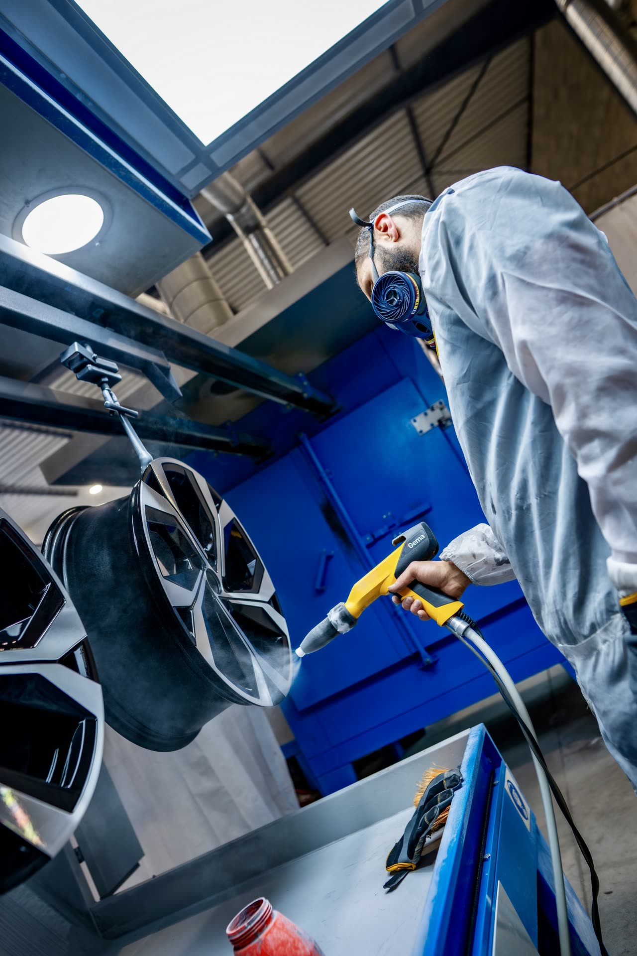 Thermopoudrage d’une jante par un technicien Thermopoudrage d’une jante par un technicien